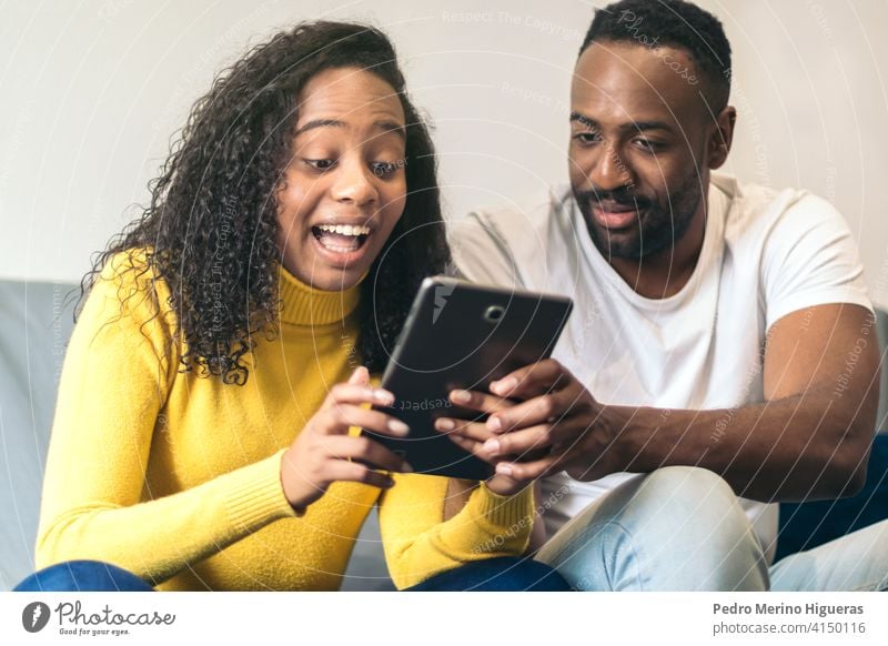 afro american couple watching tablet at home man woman internet black people happy technology smiling young online movie lifestyle african american female adult