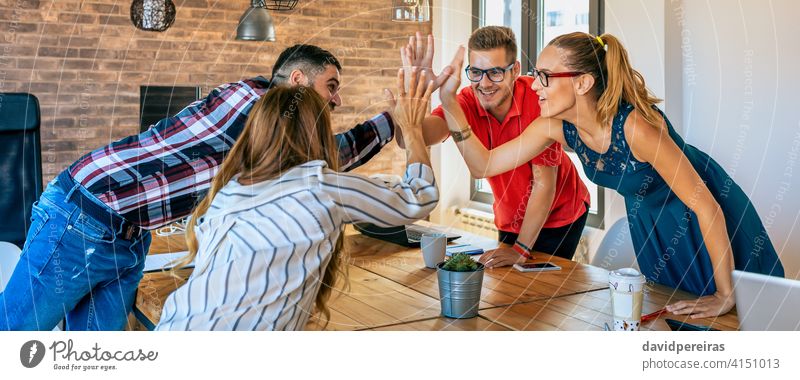 Businesspeople celebrating a success high-fiving businesspeople celebrate high five successful win teamwork office banner web header happy panorama panoramic