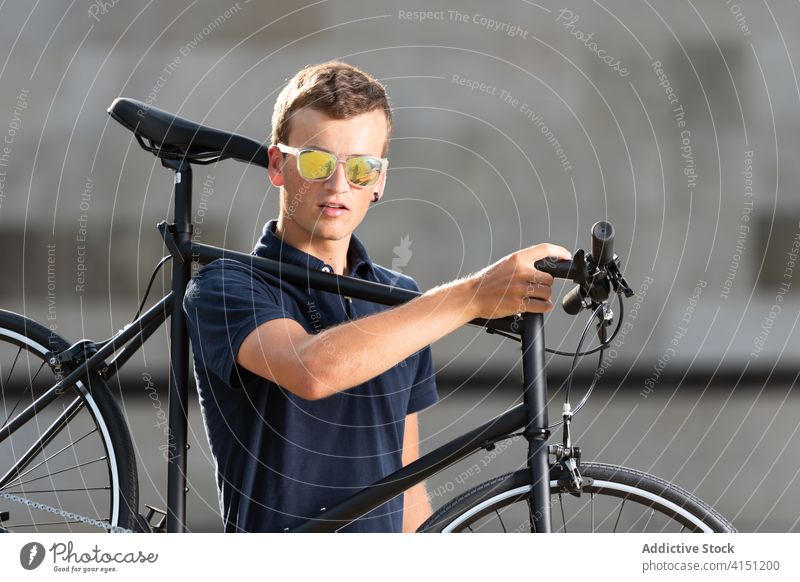 Man carrying his bicycle on shoulder adult bike blond casual caucasian cycling cyclist walking holding lifestyle male man millennial mobility modern people
