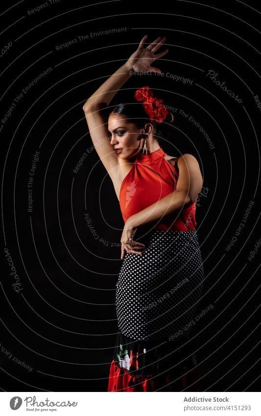Passionate woman dancing Flamenco against black background flamenco dance perform passion hispanic tradition grace move elegant dancer young female red style
