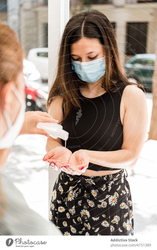 Woman in medical mask disinfecting hands before entering salon coronavirus sanitizer protect entrance client new normal women patient staff customer treat