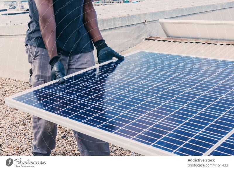 Ethnic man with solar panel on construction site industrial alternative work sustainable renewal ethnic black african american together sunny area modern walk