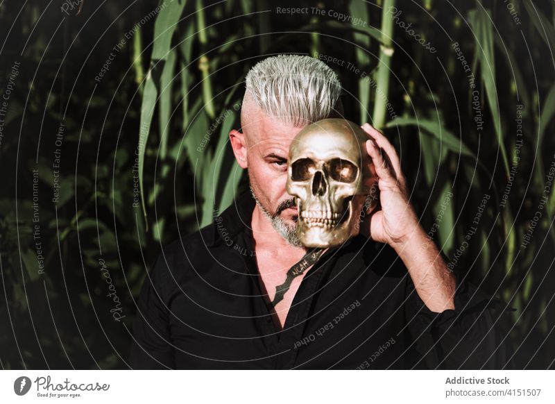 Serious hipster man with skull brutal serious beard confident hard strong challenge adult male independent tattoo gray hair middle age style mature masculine