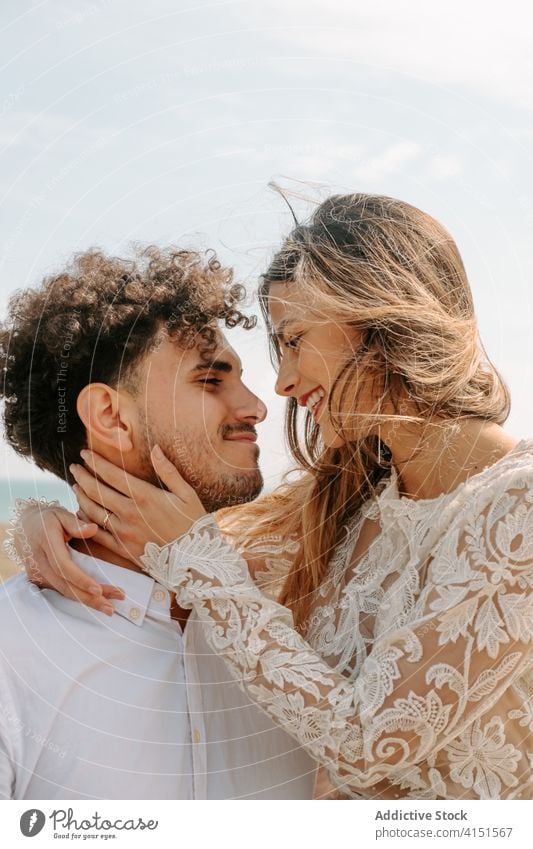 Happy newlywed couple hugging on beach romantic happy cuddle gentle enjoy together relationship love embrace marriage tender cheerful sensual smile content
