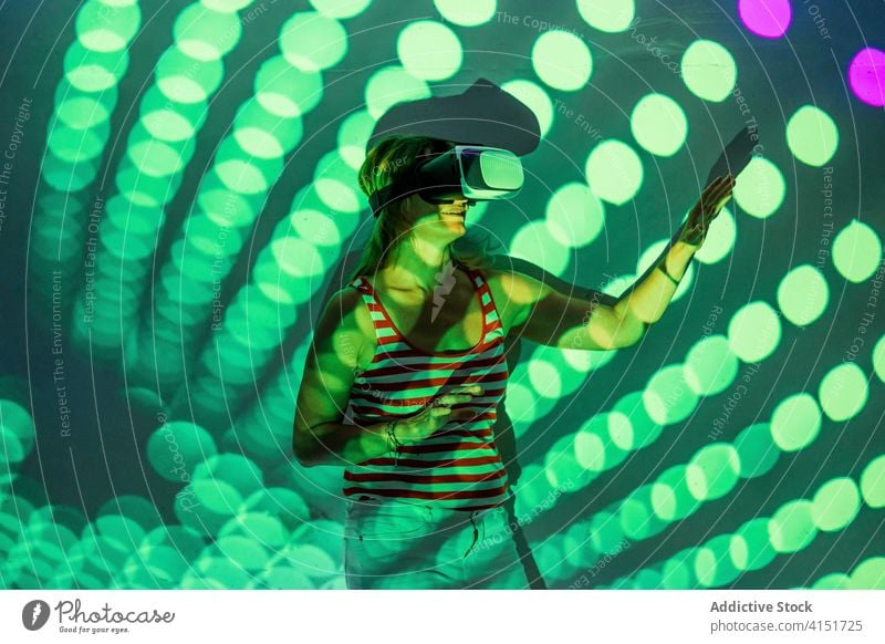 Woman in VR goggles exploring virtual reality woman vr headset touch experience explore illuminate projector technology innovation gadget entertain digital