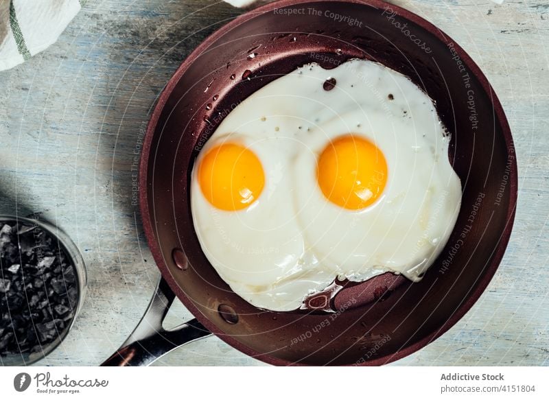Fried egg. view of two fried eggs on a frying pan. breakfast protein cooking food cooked cholesterol plate meal hot yellow fat oil yolk diet fresh kitchen