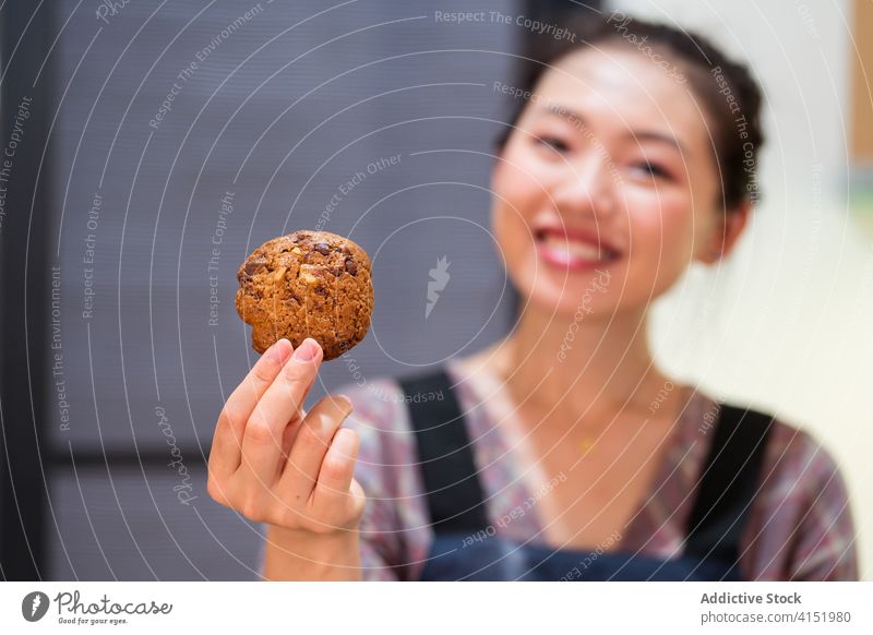 Content woman demonstrating oatmeal cookie baker happy delicious home cuisine dessert cereal grain satisfied confectionery pastry tasty show demonstrate ethnic