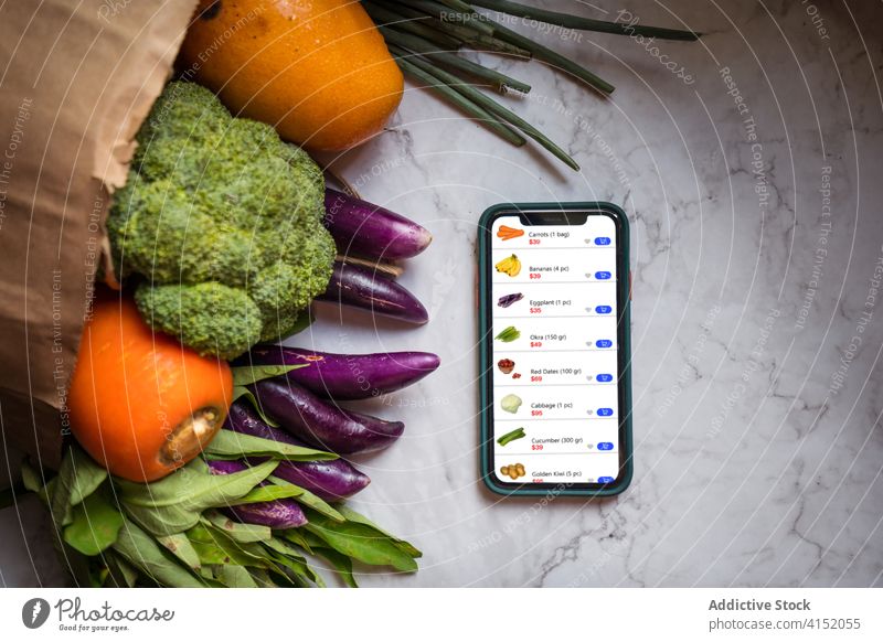 Smartphone and fresh groceries on table online shop app order grocery delivery smartphone food e commerce package remote vegetable fruit consumerism mobile