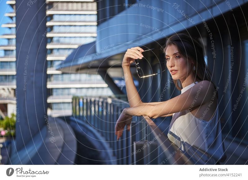 Thoughtful young woman standing near modern building thoughtful pensive lonely think urban sad female contemporary contemplate lifestyle dream alone serious