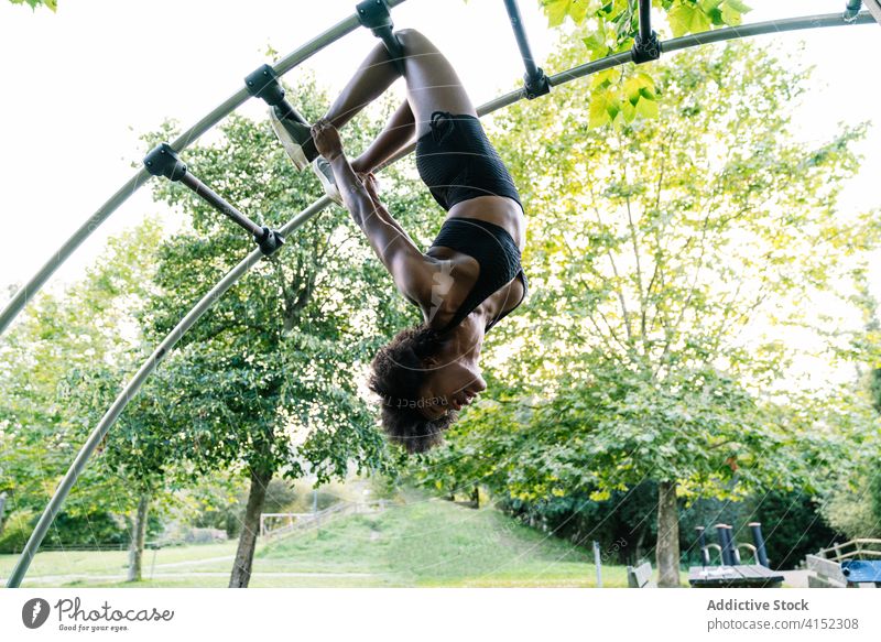 Fit woman exercising on sports ground fitness training ladder hang workout sporty exercise equipment young african american black ethnic park sportswoman