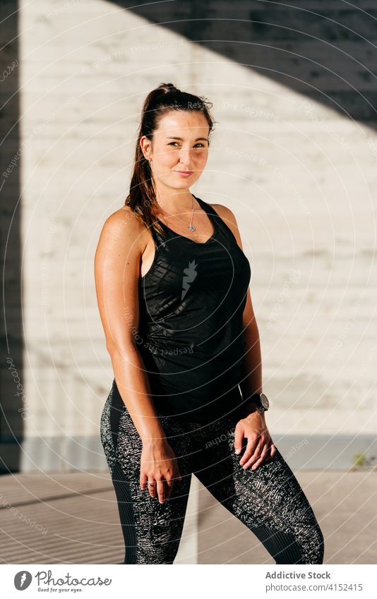 Sportswoman resting during training on street sportswoman workout stand city muscular athlete healthy female wellness sportswear physical exercise body effort