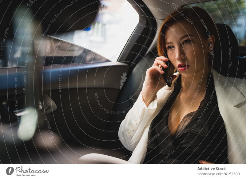 Businesswoman using smartphone in car businesswoman talk audio busy female entrepreneur luxury cellphone device mobile online communicate connection vehicle