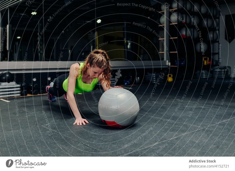 Sportswoman exercising with medicine ball in gym training exercise strong athlete workout plank sportsman wellness power wellbeing physical vitality endurance