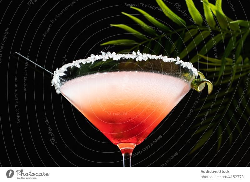 Tropical Margarita Cocktail with Grenadine placed on glittery table gourmet liqueur salt background celebration red taste cooled light vertical lime twist