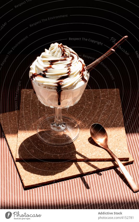 Chocolate ice cream topped with cream and chocolate sauce patisserie bowl whip melt twirl fudge sundae coasters closeup seasonal softness dairy flavored creamy