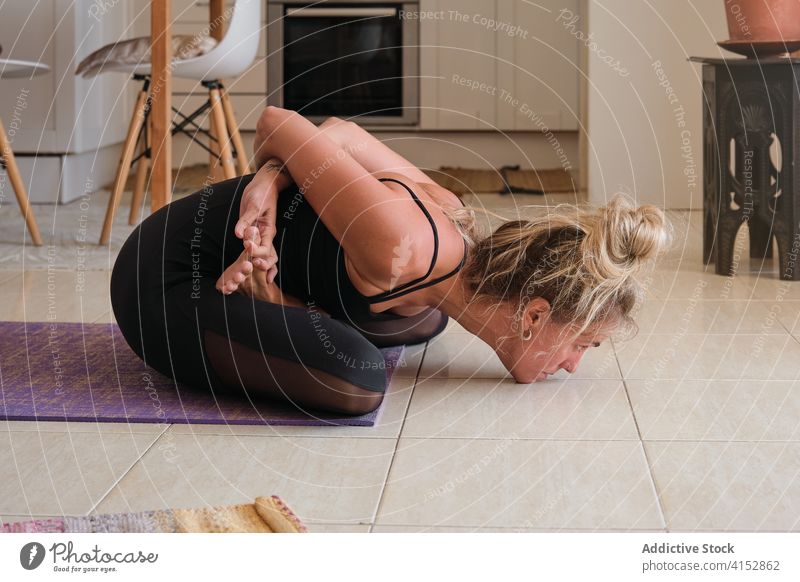 Woman doing yoga while stretching her back at home wellbeing pilates meditation mindfulness muscle gymnastics gesture balance agility exercising relaxation