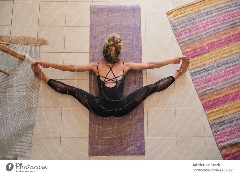 Aerial photo of a woman doing yoga while stretching at home aerial drone meditation mindfulness muscle gymnastics balance agility exercising relaxation routine