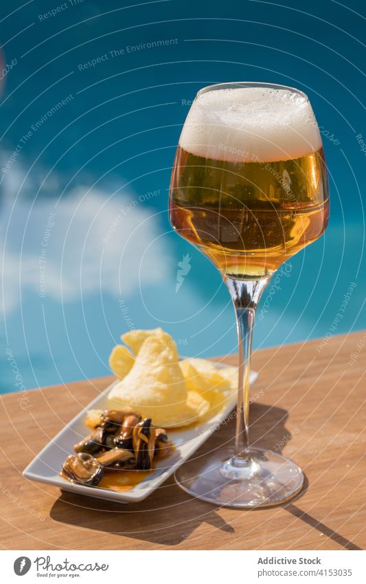 Glass of beer and snacks at poolside drink glass fresh beverage alcohol refreshment cool tasty mussel lemon cold delicious gourmet serve goblet food gastronomy