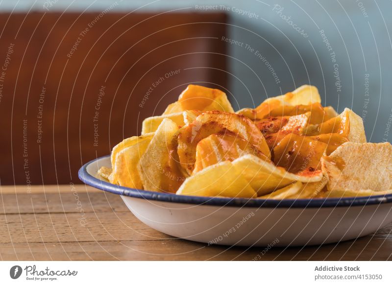 Delicious potato chips in bowl crispy delicious home food snack appetizer paprika pile crunch crust wooden table nutrition cuisine unhealthy homemade fast food