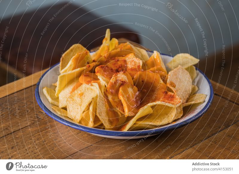 Delicious potato chips in bowl crispy delicious home food snack appetizer paprika pile crunch crust wooden table nutrition cuisine unhealthy homemade fast food