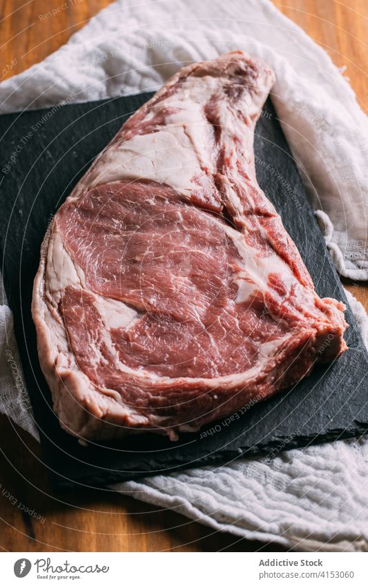 Piece of raw meat on table beef piece kitchen fresh cuisine food uncooked natural slate board wooden gourmet nutrition meal rustic home slice recipe delicious