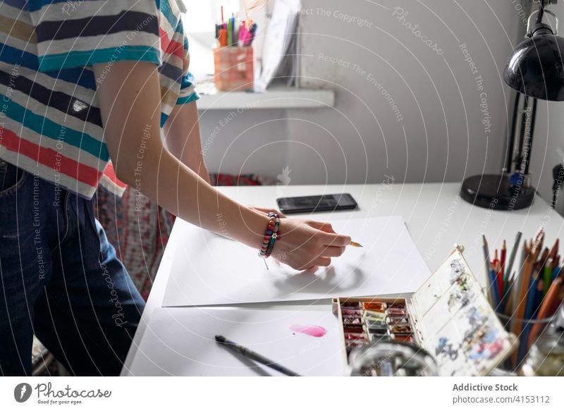 Creative woman painting on paper in workshop artist create watercolor online tutorial smartphone using female internet creative device gadget video hobby