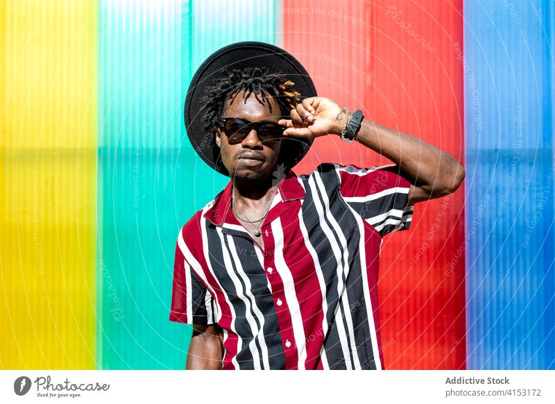 Stylish ethnic man in sunglasses and hat style fashion trendy colorful stripe young modern male african american black hipster multicolored confident accessory