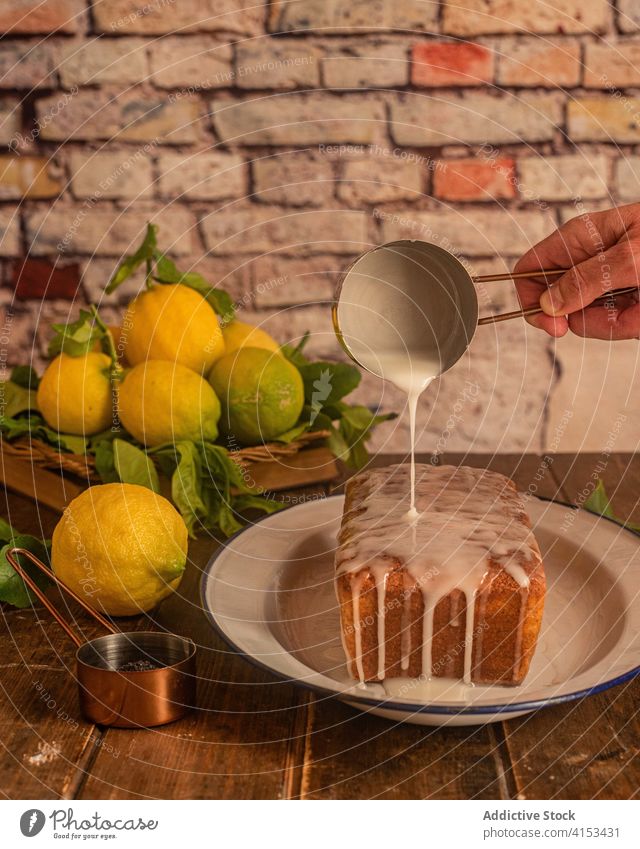 Cook pouring glaze over lemon cake poppy baked pastry sweet dessert prepare cook icing food homemade fresh hand cuisine yummy spill kitchen recipe culinary meal
