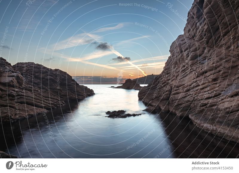 Seascape with rocky shore during sunset seaside landscape sky calm water scenery san telmo mallorca spain rough ocean amazing evening coast tranquil scenic dark