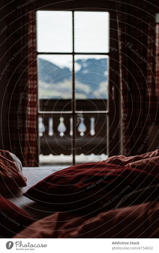 Interior of hotel room in mountains window interior cozy comfort bedroom highland design style peaceful curtain pillow soft residential house decor serene