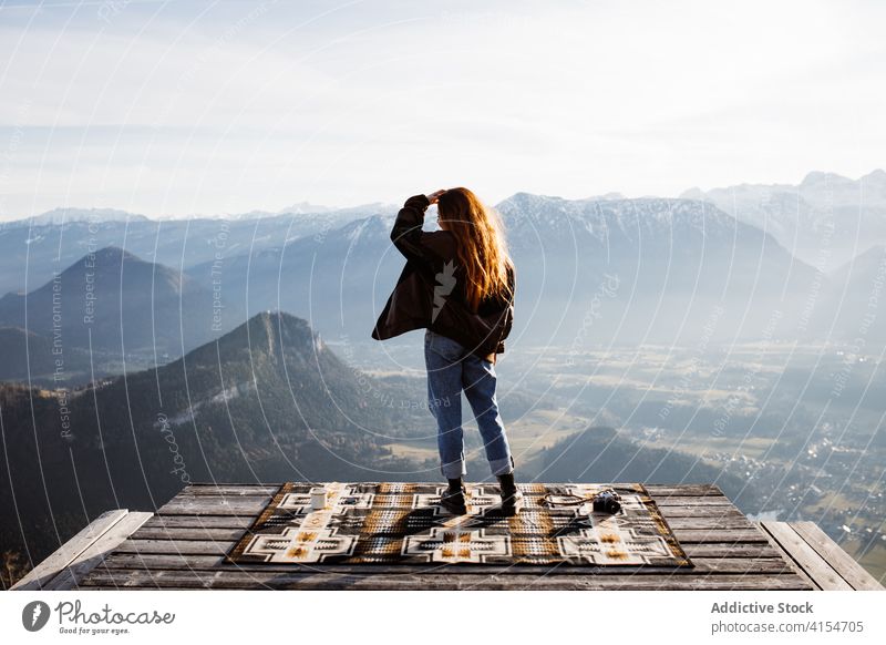 Traveling woman on wooden terrace in highlands viewpoint stand mountain morning traveler fog sunbeam tranquil enjoy germany austria tourist scenery amazing