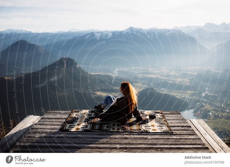 Traveling woman on wooden terrace in highlands viewpoint mountain morning traveler sitting fog sunbeam tranquil enjoy germany austria tourist scenery amazing