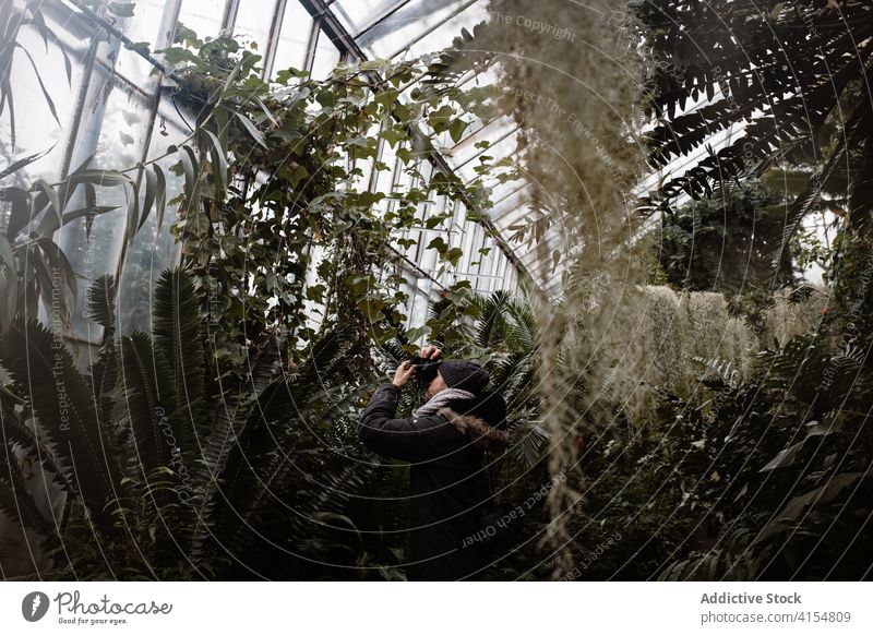 Photographer taking pictures of plants in greenhouse photographer glasshouse exotic take photo hothouse tropical grow memory scottish highlands scotland uk
