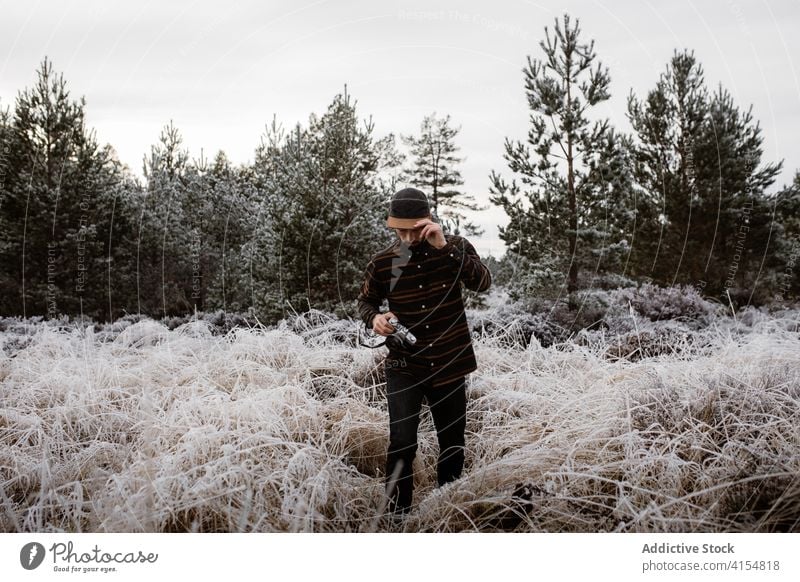 Male photographer in frozen field in winter man snow frost photo camera meadow season male scottish highlands nature grass cold vacation white weather scenic
