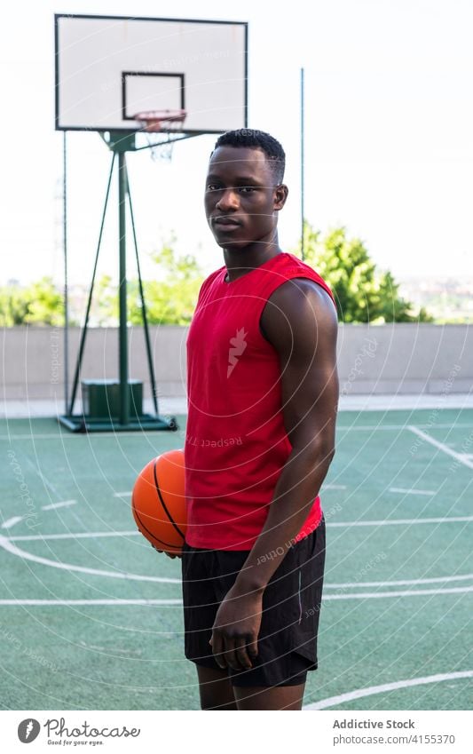 Black male athlete with basketball on sports court player man sports ground playground calm determine ethnic black african american summer game sportswear