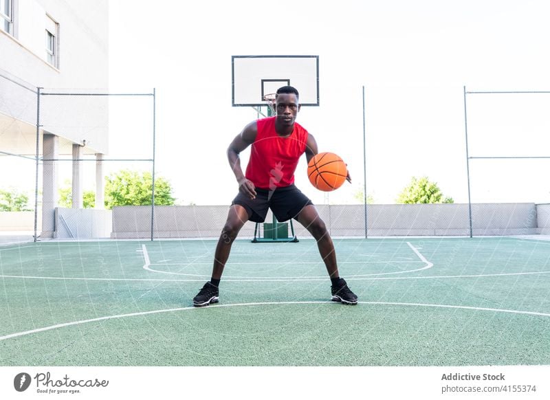Concentrated black man playing basketball on court player sports ground playground serious tactic focus male african american ethnic modern professional healthy