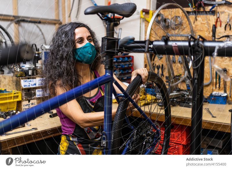 Woman fixing bicycle wheel in workshop repair woman mechanic spoke maintenance bike occupation service female professional job labor busy skill workplace manual