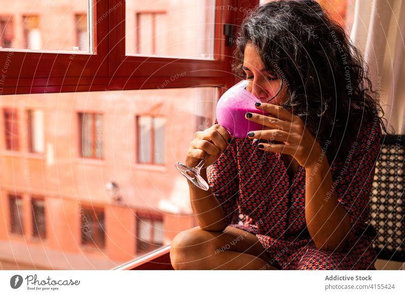 Female relaxed at home drinking healthy smoothie woman tasty juice nature fresh delicious cocktail fruit vegetarian diet tropical kefir thoughtful pink windows