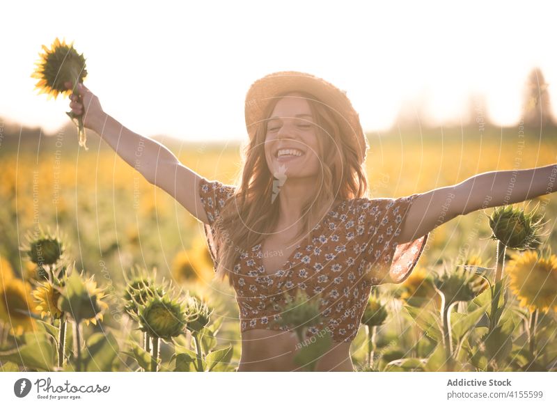 Young woman having fun in sunflower field summer happy enjoy freedom carefree bloom nature harmony cheerful young female hat countryside blossom meadow season