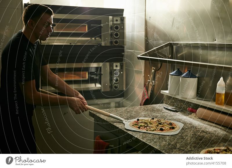 Man taking raw pizza on shovel before baking man take cook prepare oven tradition italian kitchen ingredient food process cuisine culinary fresh vegetable