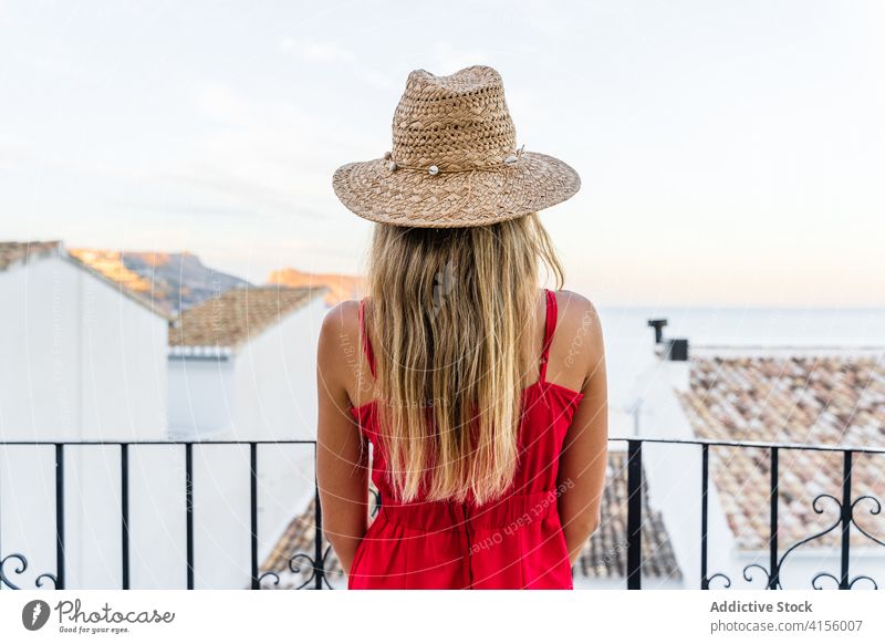 Traveling woman with sunhat enjoying summer celebrate vacation tourist straw hat terrace carefree freedom female travel cityscape trip stand weekend idyllic