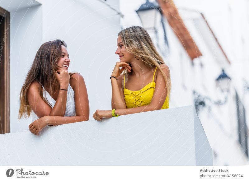 Happy women standing on terrace of building in city friendship enjoy summer vacation relax positive stroll town happy smile together modern urban weekend rest