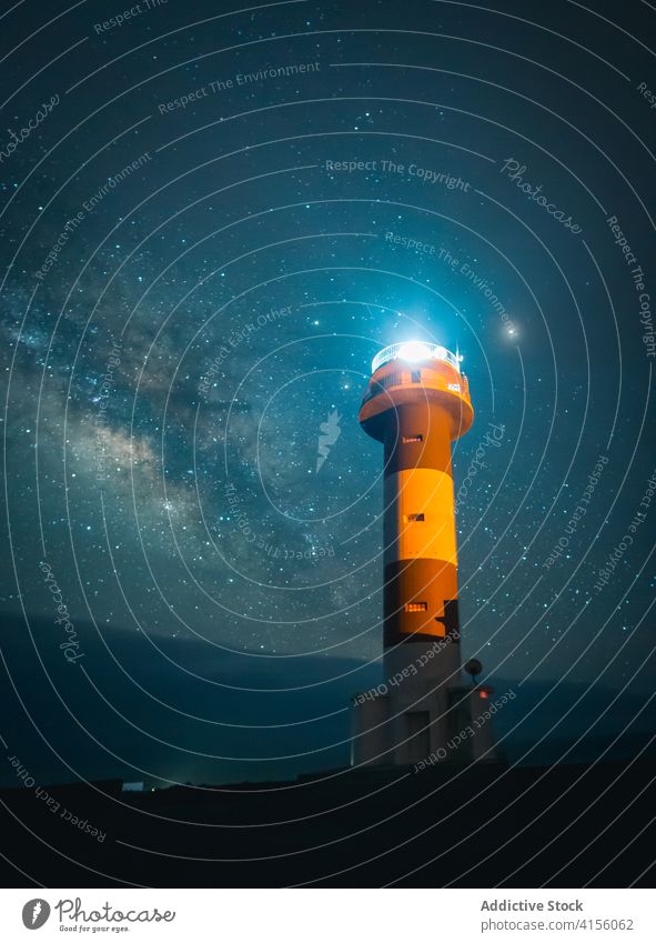 Illuminated beacon at seaside at night lighthouse sky illuminate navigate glow starry milky way tower coast dark landscape seashore evening beach coastline