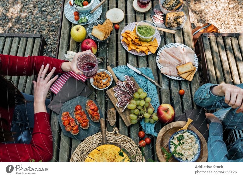 Crop women at table with food in forest picnic together eat various woods delicious valle del jerte caceres spain tasty wooden meal friend lunch vacation snack