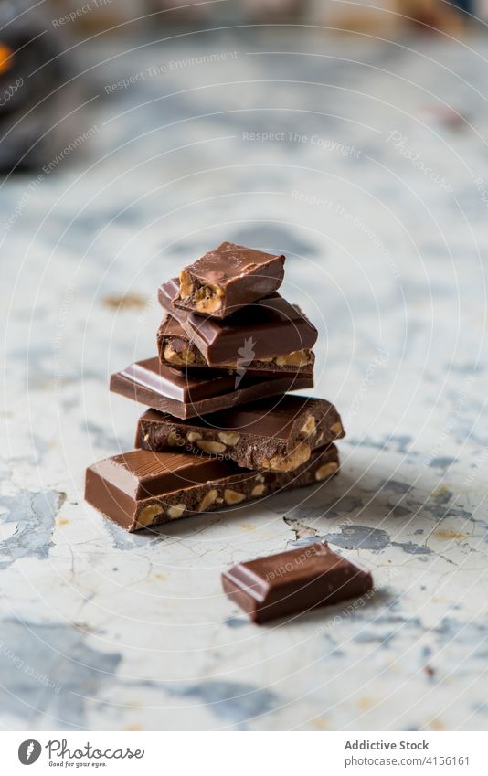 Pieces of chocolate bar with nuts piece stack sweet dessert food yummy candy tasty delicious broken cocoa treat ingredient dark brown pile appetizing meal