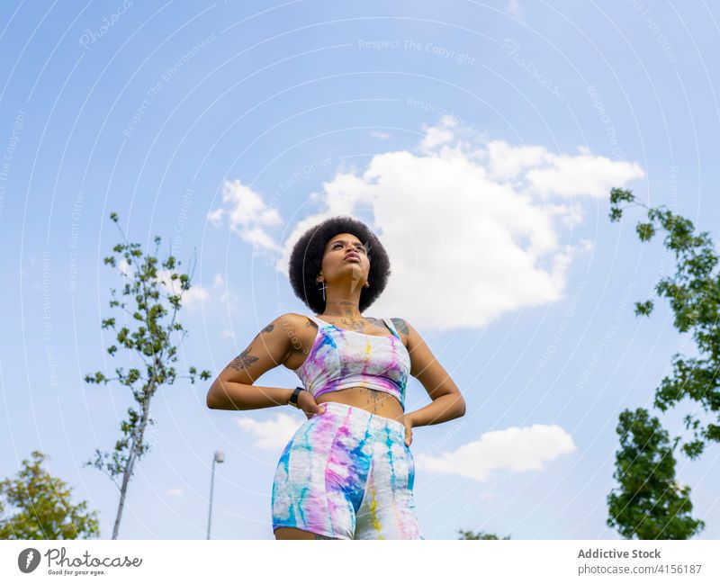 Confident sportswoman standing on lawn in city training break determine sportswear summer athlete ethnic black african american trendy fitness healthy afro