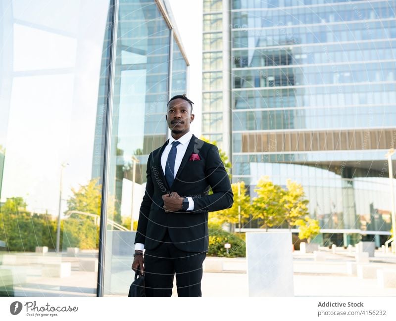 Stylish black businessman walking along street city center determine entrepreneur classy costume office building male ethnic african american elegant suit glass