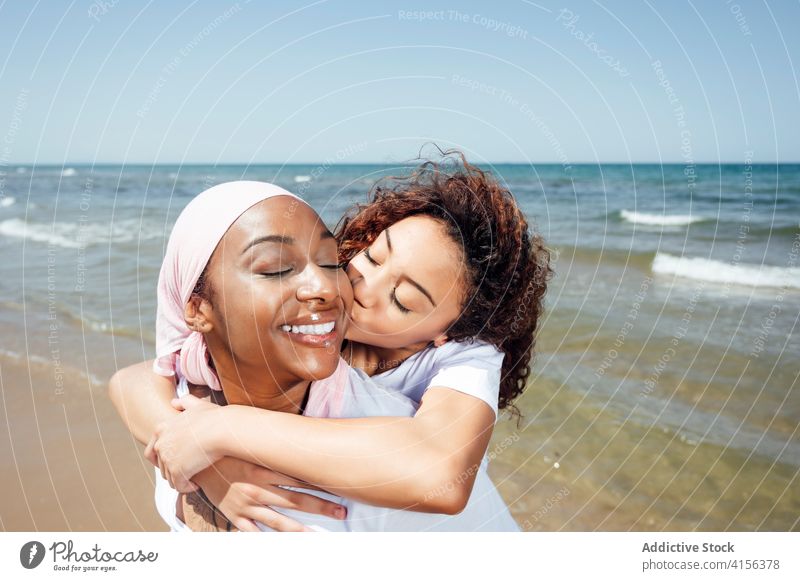 Cheerful mother piggybacking daughter on beach ride having fun bonding relationship cheerful together ethnic black african american happy seaside summer smile