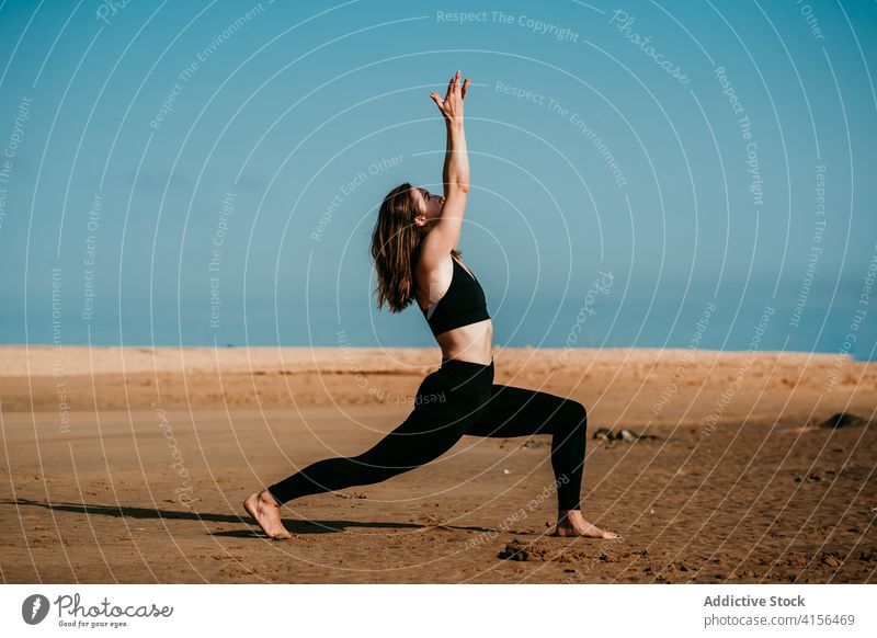 Flexible woman doing yoga in Crescent Variation beach pose practice flexible Virabhadrasana summer female slim sportswear fit relax