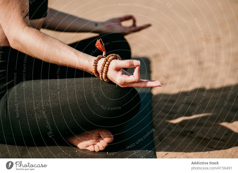 Anonymous relaxed woman in Lotus pose on beach lotus pose yoga padmasana meditate mudra mat zen peaceful female healthy fit nature energy position spirit soul